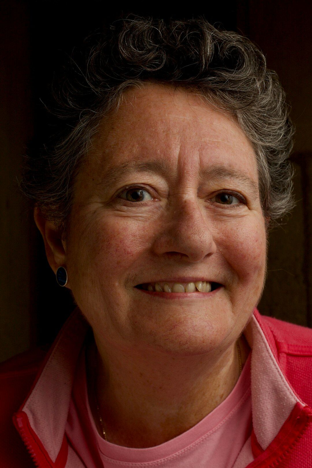 Studio portrait of a smiling older woman with short grey hair